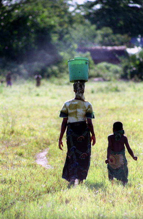 Woman carrying water with her daughter. (Category:  Travel)