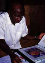 Mzee looking at Hussein's portfolio. (Category:  Travel)