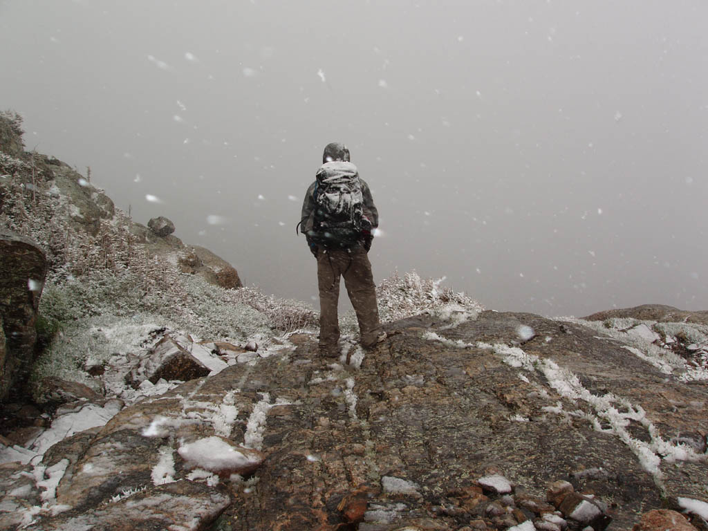 Ryan in the blizzard at the base of Petit Grepon. (Category:  Rock Climbing)