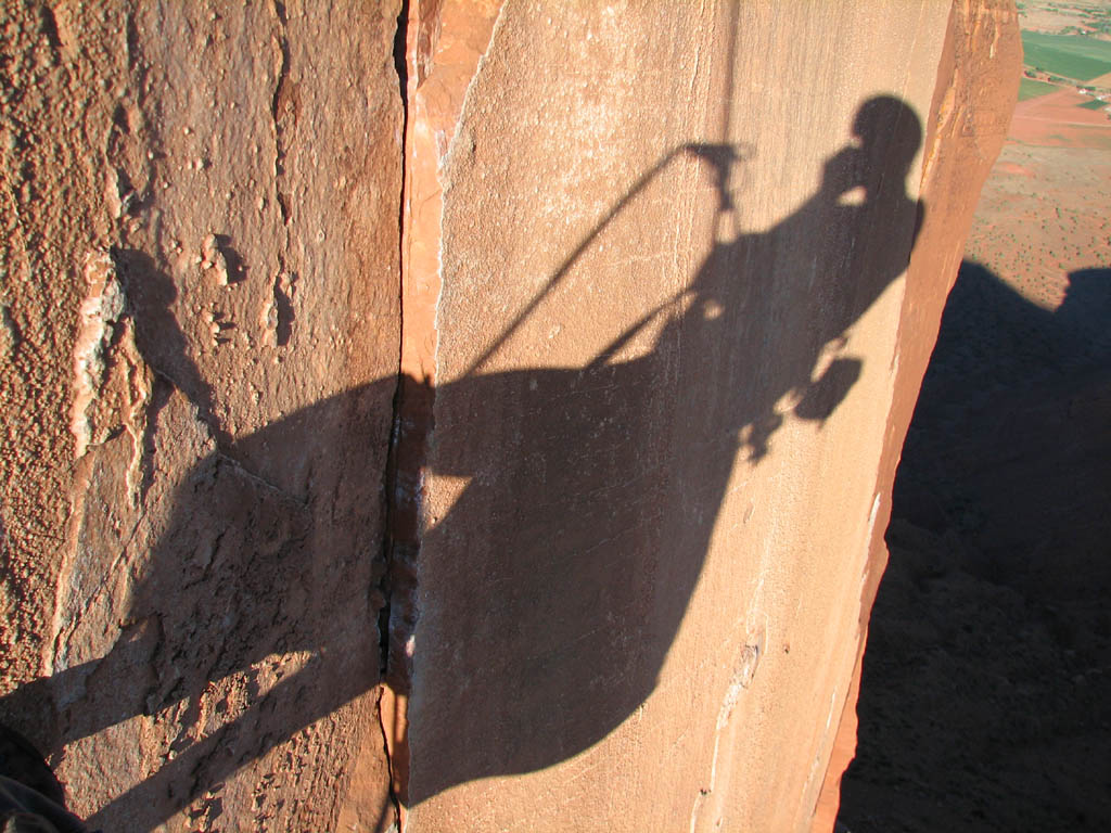 My shadow while rappelling off Castleton.  The large shadow underneath me is the haul bag which was dangling from my harness. (Category:  Rock Climbing)