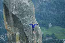 Corbin slacklining Lost Arrow Spire.  He is wearing a waistbelt harness and a safety leash, though it isn't really visible in the picture. (Category:  Rock Climbing)