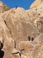 Aramy finishing Coyote in the Bushes with Kristin belaying and Kenny hanging out on the starting ledge. (Category:  Rock Climbing)