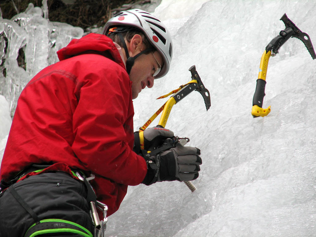 Placing a screw. (Category:  Ice Climbing)