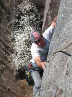 Nick reaching the top of Morning After.  The cherry tree below was just starting to bloom. (Category:  Rock Climbing)