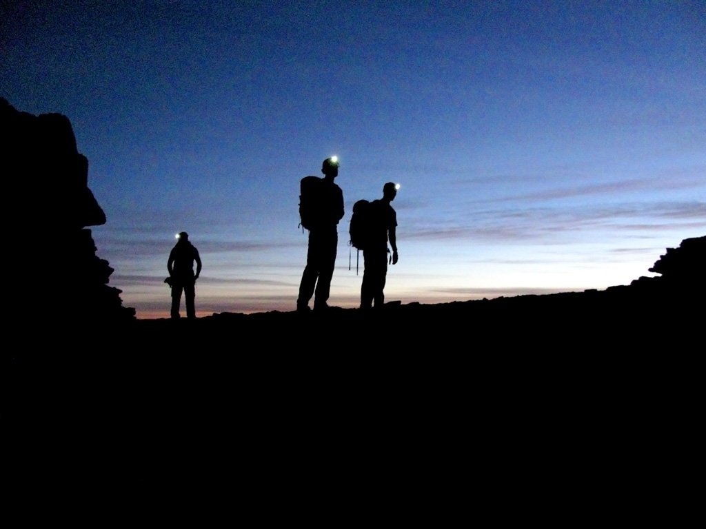 Josh, Keith and Guy reaching the base of Castleton just as the sun starts to lighten the sky. (Category:  Rock Climbing)