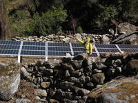 Young posing in front of the large solar panels donated by a Korean university. (Category:  Travel)