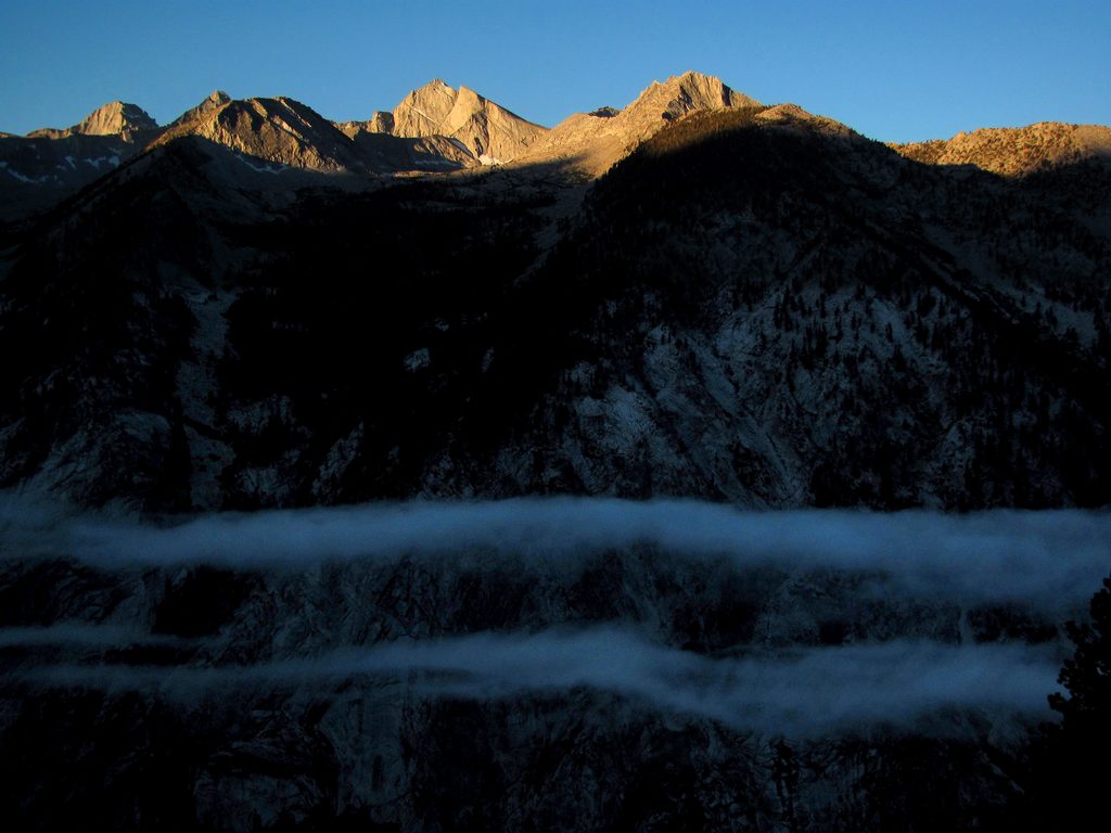 Sun just hitting the peaks across the valley as low clouds hang out in the shadows below. (Category:  Rock Climbing)