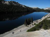 Beth and Mike walking to the base of Stately Pleasure Dome above the still waters of Tenaya Lake. (Category:  Rock Climbing)