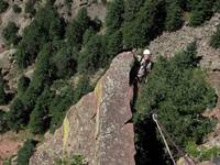 Tom at the top of Rewritten's very exposed final arete. (Category:  Rock Climbing)