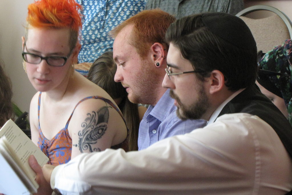 Beki, Uel, and Saul engaged in book-sharing. (Category:  Party)