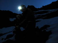 Mike putting on his crampons at the base of the snowfield. (Category:  Rock Climbing)