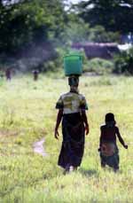 Woman carrying water with her daughter. (Category:  Photography)
